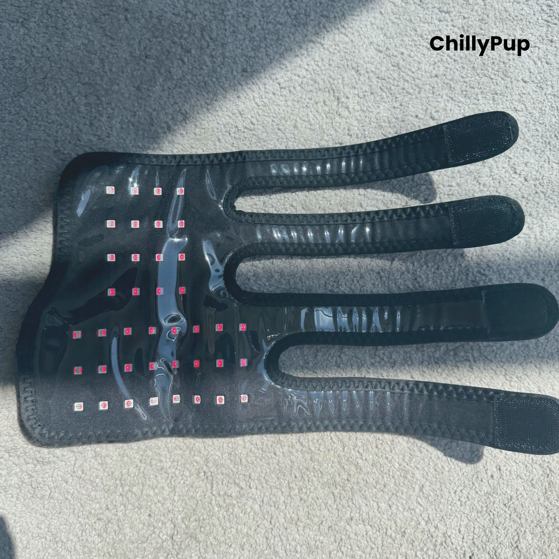 A black redlight leg wrap facing upwards on a carpet with ChillyPup branding.